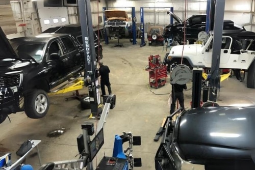 Expert vehicle maintenance in Grand Junction, CO at Barney Brothers Off Road and Repair. Image of vehicles on lifts being worked on in the Barney Brothers shop bay area with tools and state of the art machines.