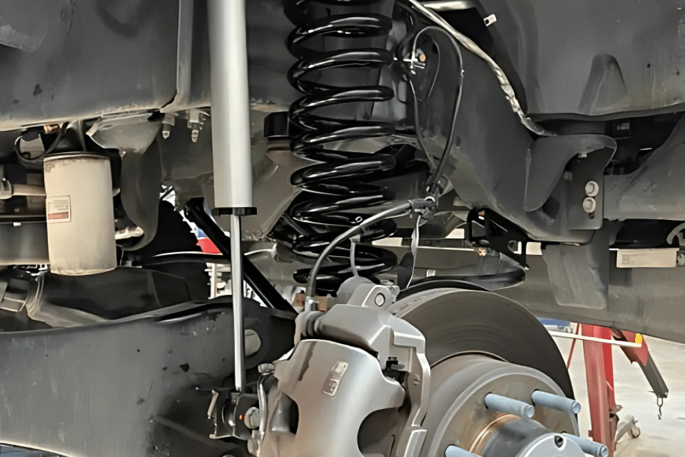 off-road suspension, Off-Road and Repair in Grand Junction, CO at Barney Brothers Off-Road and Repair. Close-up of a vehicle's suspension system, showing a new shock absorber, coil spring, and brake assembly.